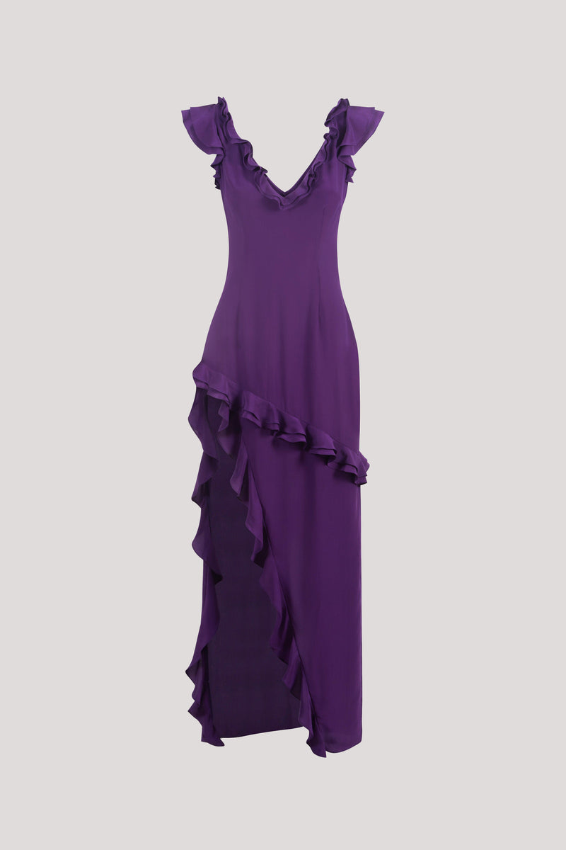 A purple sleeveless dress with ruffled shoulder details, a V-neckline, and an asymmetrical ruffled hem, shown against a solid light gray background.